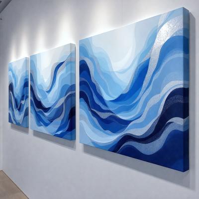 The primary subject of the image is a painting of a blue ocean. The painting is displayed on a white wall, which serves as the setting and background. The visual style of the painting is a combination of digital art and illustration, creating a vibrant and dynamic scene. The dominant colors in the painting are blue and white, giving the image a calming and serene atmosphere.